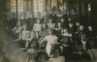 Élèves assis derrière leurs bureaux posant pour un portrait - English Photographer
