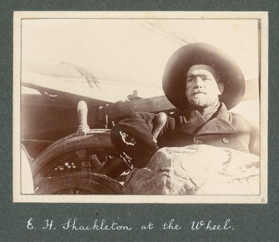 E H Shackleton debout près de la roue du 