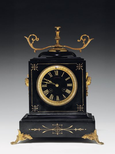 Pendule de cheminée en pierre noire, avec décoration incisée, avec pieds, ornements et accessoires en laiton doré, par Jausions de Pau, France, vers 1876-78 - French School