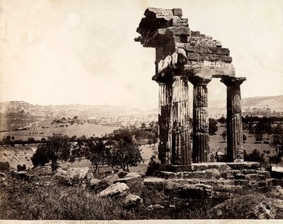 Vue des quatre colonnes restantes soutenant un entablement du Temple de Castor et Pollux dans la Valle dei Templi, Agrigente. Un panorama de la ville est visible à l