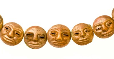 Un collier trouvé autour du cou de la momie avec de petits visages en or. - Ira Block