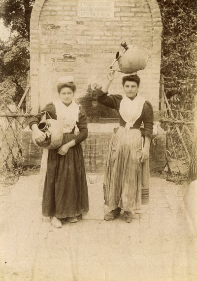 Deux jeunes femmes portant des vêtements traditionnels et des jarres en terre cuite près d