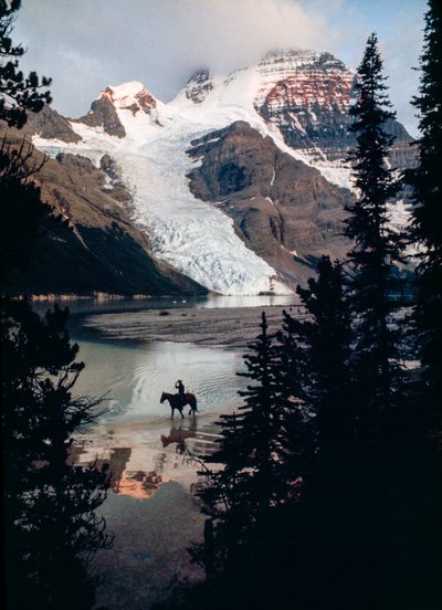 Cheval solitaire, cavalier réfléchissant sur le lac au pied du plus haut sommet du Canada. Mont Robson... - James L Stanfield