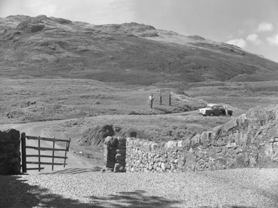 Vue de la route passant par le col de Hard Knott, deux personnes debout près d
