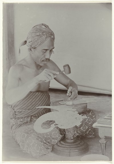 Homme javanais fabriquant une image ressemblant à une figure humaine avec un marteau et des instruments - Kassian Cephas