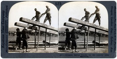 Hommes chinois sciant du bois pour l