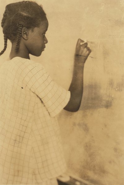 Jeune fille écrivant sur un tableau noir en classe, Pleasant Green School, Marlinton, comté de Pocahontas, Virginie-Occidentale, USA vers 1921 (photo sépia) - Lewis Wickes Hine