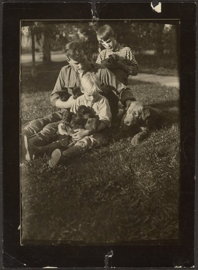 [Homme avec enfants et chiots dans la cour] - Louis Fleckenstein