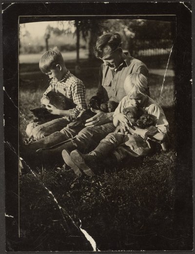 [Homme avec enfants et chiots dans la cour] - Louis Fleckenstein