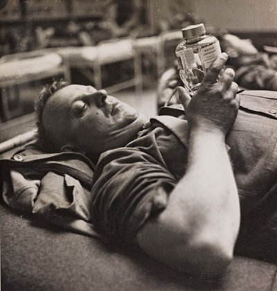 Le convalescent militaire regarde un petit flacon contenant une préparation chimique - Luigi Leoni