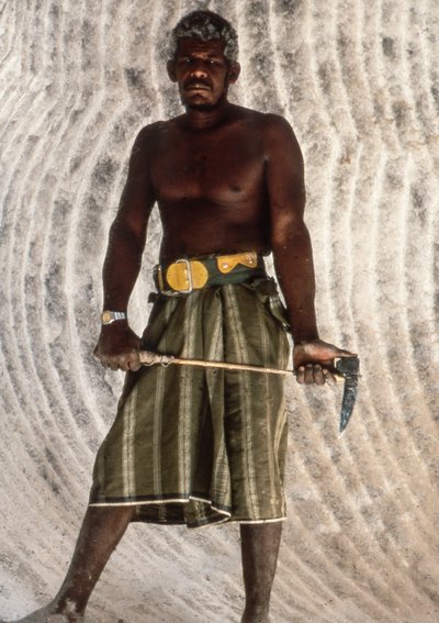 Homme yéménite tenant un pic à sel dans une ancienne mine de sel dans l