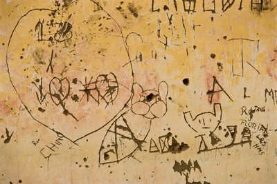 Graffiti gravé sur un vieux mur en plâtre extérieur. - Nathan Benn