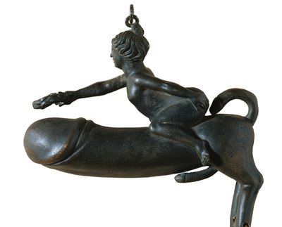 Sasamon Phallus. 1er siècle. Animal avec poitrine, jambes et queue en forme de gland, monté par une femme avec une couronne de laurier. Amulette contre le mauvais œil. Art romain. Début de l