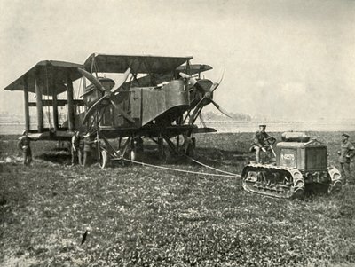 Un petit tracteur motorisé mettant en position une énorme machine de bombardement de la RAF, 1919 - Unbekannt