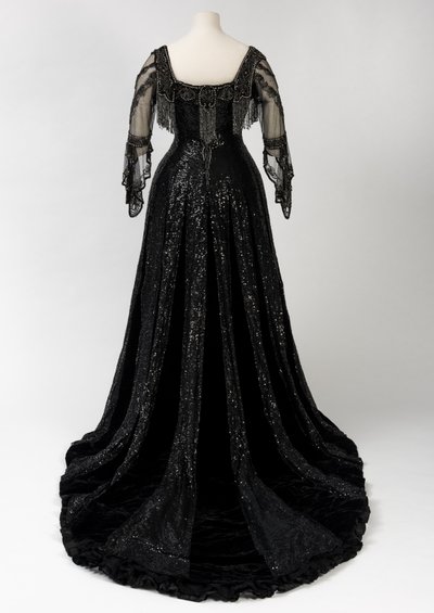 Robe de soirée noire portée par la reine Alexandra, avec décoration de perles et de sequins et incorporant la bande de nom en soie noire et lettres dorées de la reine Alexandra, fabriquée par Barolet de Knightsbridge, Londres 1908-1910 - Unbekannt
