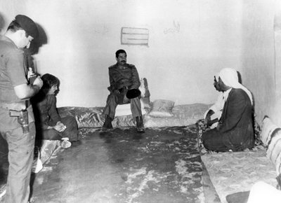 Saddam Hussein visitant une maison paysanne à Bassora, Irak - Unbekannt