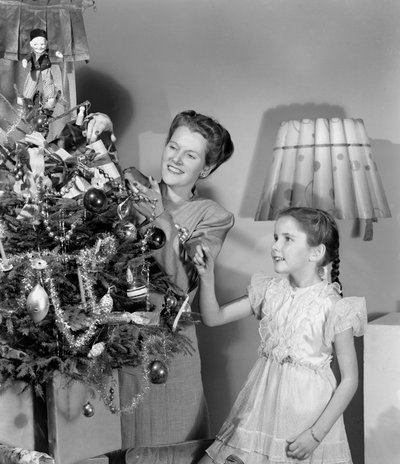 Femme et fille décorant un arbre de Noël, vers 1948 - Unbekannt