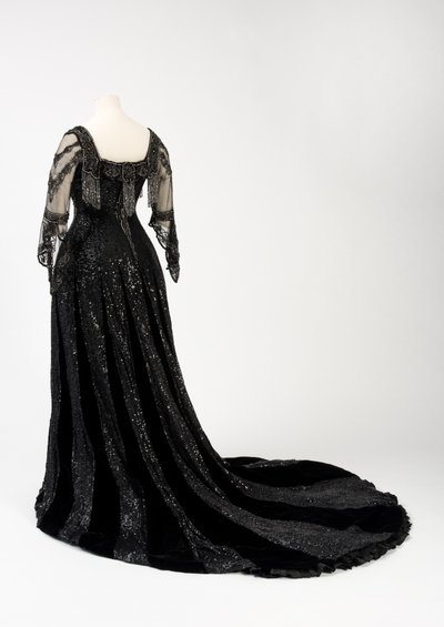 Robe de soirée noire portée par la reine Alexandra, avec décoration de perles et de sequins et incorporant la bande de nom en soie noire et lettres dorées de la reine Alexandra, fabriquée par Barolet de Knightsbridge, Londres 1908-1910 - Unbekannt
