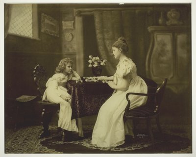 Femme et enfant jouant aux dominos à table - Unknown