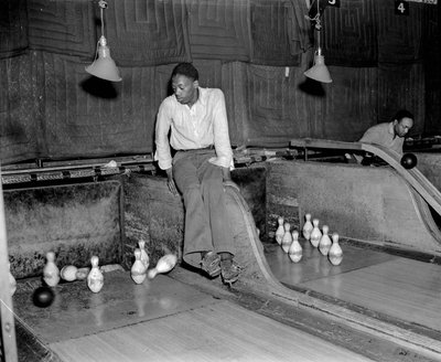 Homme afro-américain assistant aux quilles dans une salle de bowling, pour réinitialiser manuellement les quilles - Volkmar Wentzel