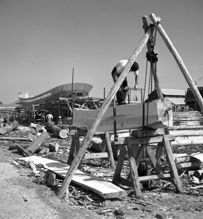 Artisans constructeurs de bateaux portugais construisent un bateau de pêche en bois en utilisant une scie à tronçonner - Volkmar Wentzel