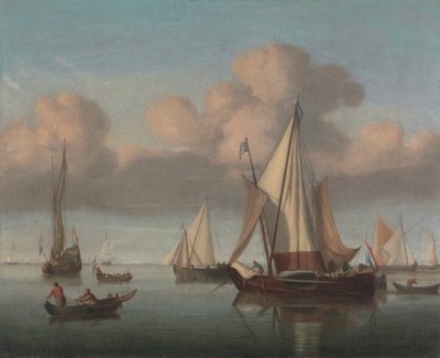 Un kaag au mouillage avec les voiles hissées et un yacht d