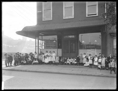 Des enfants posent devant une succursale non identifiée de la bibliothèque publique de Queens Borough, New York, vers 1910 - William Davis Hassler
