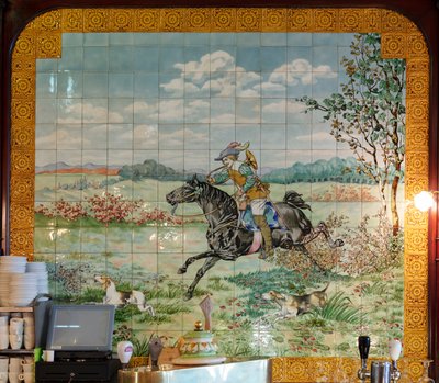 Vue intérieure, panneau de carreaux, peintre Furcy Ernest Tondeur, exécutant Boch Frères La Louvière, deuxième panneau montre une scène de chasse avec un cavalier galopant avec un cor de chasse - . .