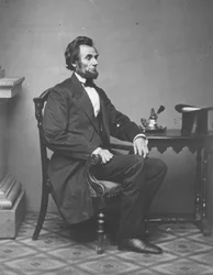Abraham Lincoln, portrait en pied, assis, 1861