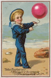 Garçon marin tenant un ballon rouge