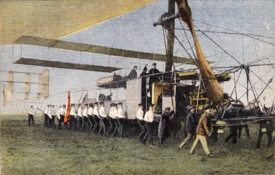 De Compiègne à Londres en dirigeable : des soldats anglais remorquent le dirigeable Bayard-Clément dans son hangar à Wormwood Scrubbs. Gravure. Un des journaux « Le petit parisien » du 30/10/1910. Collection privée.