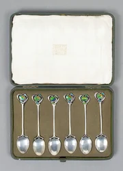 Un ensemble de cuillères en argent Cymric avec des extrémités émaillées conçues par Archibald Knox