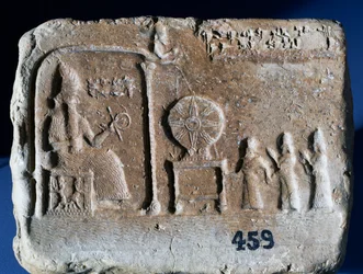 Tablette votive représentant Shamash, le dieu solaire de Sippar, assis dans son sanctuaire, tandis que le roi babylonien Nebopaliddin est conduit en présence du dieu par deux figures. Art babylonien, IXe siècle av. J.-C.