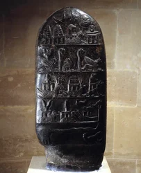 Antiquité orientale : stèle (ou kudurru, acte de donation foncière) en calcaire noir sculptée de bas-reliefs du roi Meli-Shipak (ou Melishipak) II (1186-1172 av. J.-C.) en faveur de son fils Marduk-apla-iddina. Ils représentent les grandes divinités.
