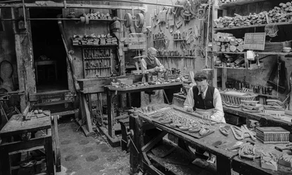 Artisans à un établi dans un atelier fabriquant de petits objets en bois qui ne ressemblent à rien