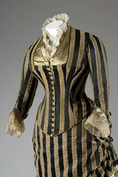 Robe de soirée, c.1884 (vue partielle oblique latérale). Satin de soie et velours coupé, dentelle, glands et franges en fil de soie. Charles Frederick Worth, France.