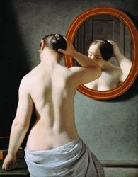 Une femme nue se coiffant devant un miroir