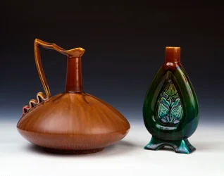 Cruche en poterie Linthorpe de forme globulaire comprimée avec glaçure caramel, verte et cramoisie et vase en poterie Linthorpe avec décoration de bourgeons de fleurs percés et glaçures marbrées vertes, bleues et brunes