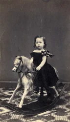 Jeune fille sur un cheval à bascule, années 1860