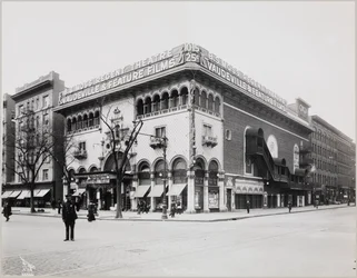 Un immense théâtre avec une façade élaborée, complète avec des arches et des balcons mauresques. Un grand panneau au sommet du bâtiment indique 