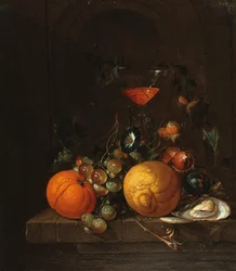 Un citron, une orange, des raisins, une huître et un verre de vin sur un rebord