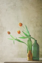 Des tulipes orange dans des bouteilles