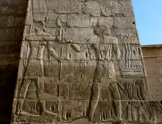 Antiquité égyptienne : temple funéraire de Ramsès III (1187-1156 av. J.-C.). Bas-relief représentant le pharaon recevant les insignes du pouvoir des mains d