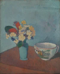 Vase avec des fleurs et une tasse