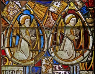 Un panneau dans la fenêtre est représentant deux anges musiciens avec des harpes parmi des fragments
