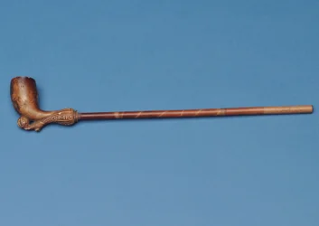 Pipe avec tige en bambou et botte sculptée frappant un ballon en dessous