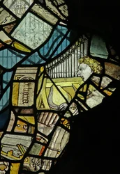Fenêtre représentant des fragments incluant un ange musicien avec un orgue