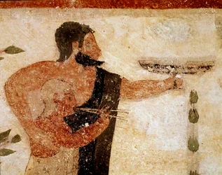 Un homme barbu présentant une coupe, près de lui un musicien (détail de fresque, 530 av. J.-C.)