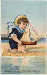 Garçon jouant avec un bateau à voile jouet