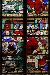 Fenêtre w2 représentant une scène de la Vie de la Vierge Marie : sa naissance avec de nombreuses personnes, sages-femmes, etc.